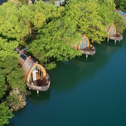 Los visitantes de estos encantadores refugios de barcos con estructura de madera en la provincia de Zhejiang pueden sentarse en las amplias cubiertas y ver las luces reflejarse en el agua. El diseño se inspira en las tradiciones locales, y las cinco salas de botes están ubicadas en un dosel de árboles (Zheng Shi)