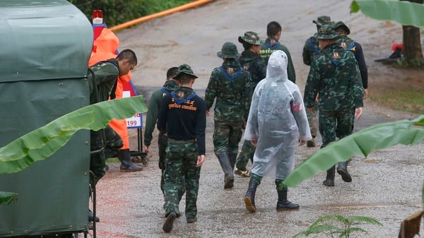 Personal socorrista en las afueras de la cueva y bajo las lluvias traídas por el Monzón (AP)