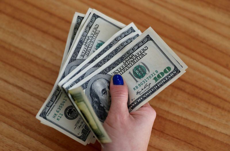 Una mujer muestra billetes de dólares estadounidenses . REUTERS/Marcos Brindicci