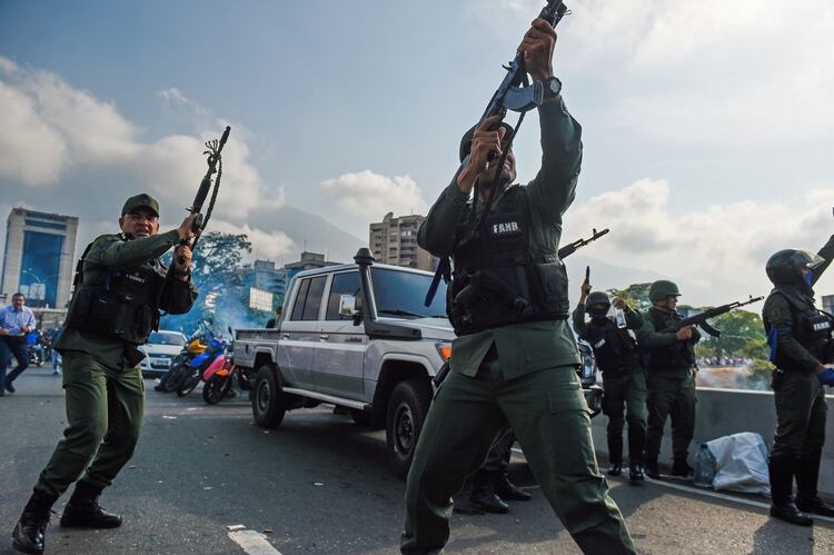 Miembros de la Guardia Nacional que se sumaron al levantamiento disparan al aire a modo de disuasión (Photo by Federico PARRA / AFP)