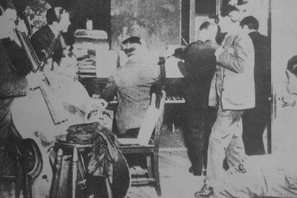 Carlos Gardel con integrantes de la orquesta de Francisco Canaro ensayando para "Viejo smoking", de 1930.