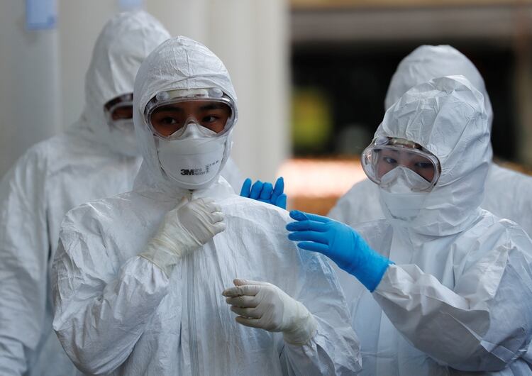 Trabajadores médicos con equipo de protección entran en una instalación hospitalaria para tratar a pacientes con coronavirus en Daegu, Corea del Sur, el 8 de marzo de 2020. (REUTERS/Kim Kyung-Hoon)