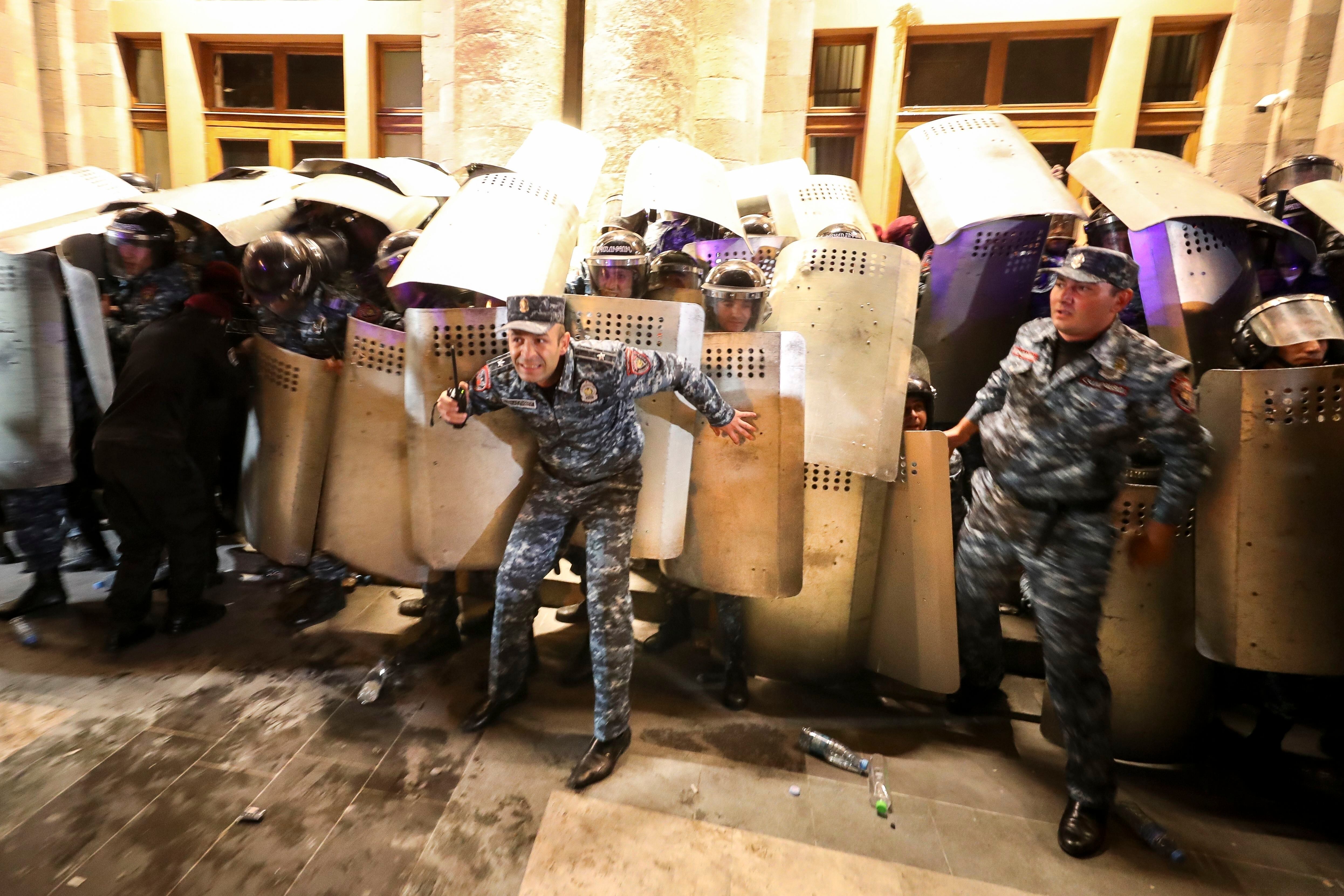 Policías intentan bloquear la entrada a un edificio gubernamental durante una protesta contra el primer ministro Nikol Pashinyán el miércoles 20 de septiembre de 2023, en Ereván, Armenia. (Vahram Baghdasaryan/Photolure vía AP)