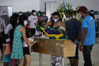 Miqueias Moreira Kokama, hijo del jefe indígena Messias Kokama, de 53 años, que falleció debido a la enfermedad por coronavirus (COVID-19), reacciona junto a sus familiares durante el funeral de su padre en el Parque das Tribos en Manaos, Brasil, 14 de mayo de 2020. REUTERS / Bruno Kelly