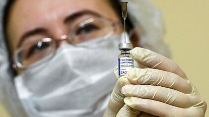 Una enfermera en Moscú sostiene una dosis de la nueva vacuna rusa contra COVID-19 (AFP)
