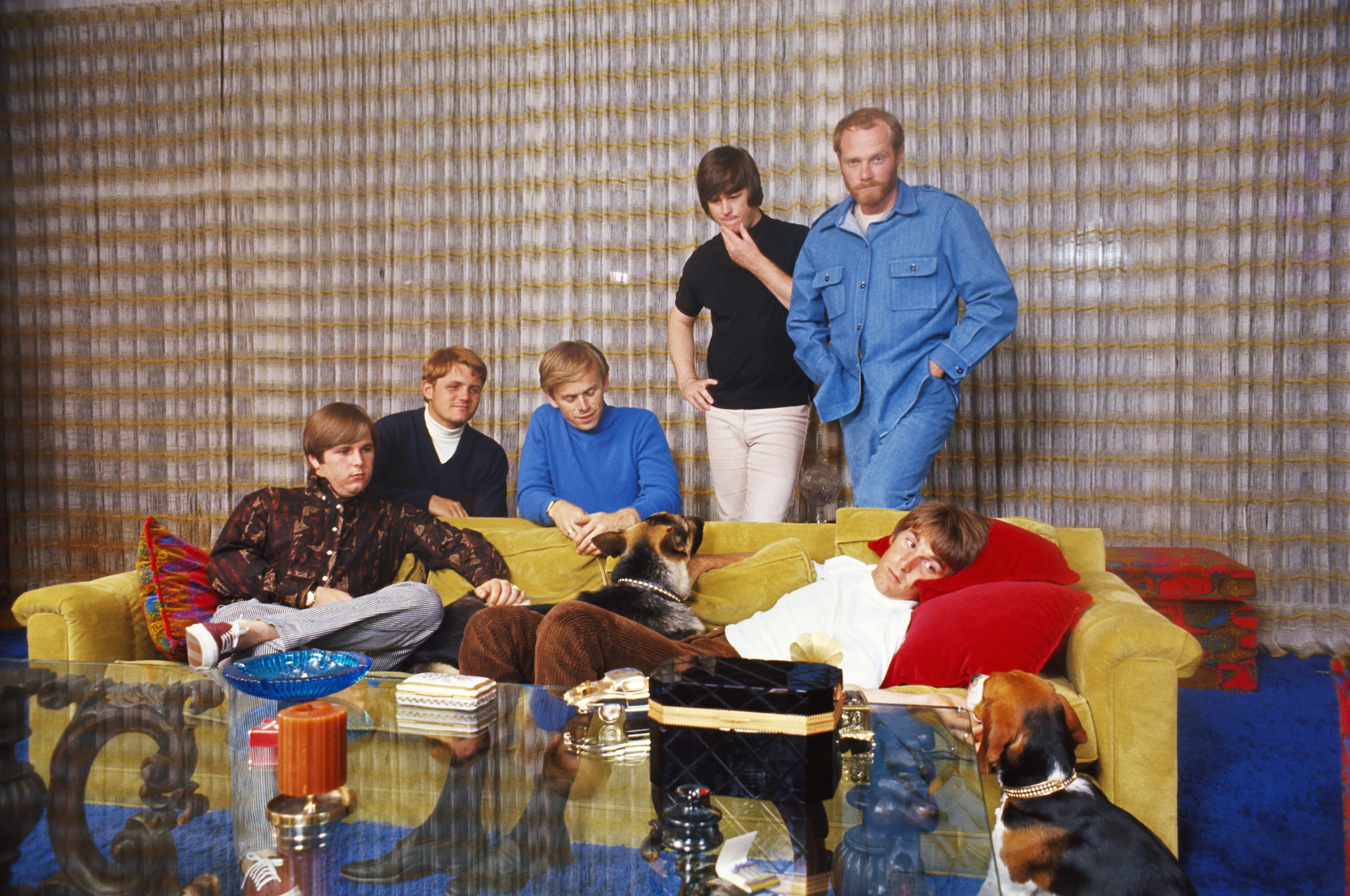 LOS ANGELES - CIRCA 1965:  Rock and roll band "The Beach Boys" pose for a portrait in a house in circa 1965 in Los Angeles, California. (L-R) Carl Wilson, Bruce Johnston, Al Jardine, Brian Wilson, Mike Love, Dennis Wilson (lying on couch). (Photo by Michael Ochs Archives/Getty Images)