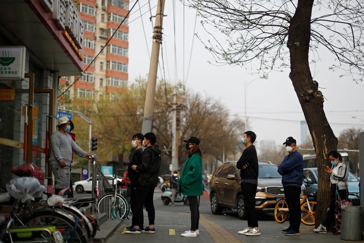 Las personas practican el distanciamiento social mientras hacen cola para ingresar a un supermercado, por la propagación del coronavirus COVID-19 en Beijing, China (Reuters)