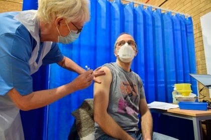 David Farrell, paciente de 51 años, recibe una de las dos vacunas de Pfizer y BioNtech en un centro de vacunación en Cardiff (Reino Unido). EFE/Ben Birchal

