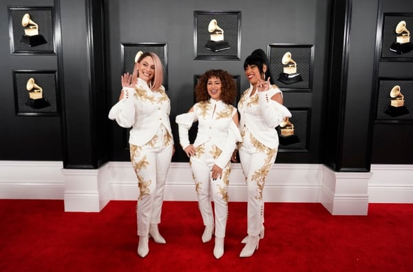 El grupo musical Flor de Toloache, nominado a mejor álbum de rock. Según María Gabriela Gurmandi, las tres lucen iguales con traje blanco y dorado, con detalles de cut out en los brazos