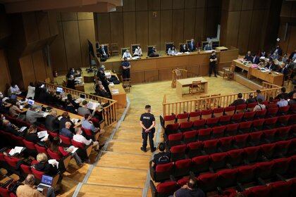 A police officer stands guard inside the courtroom during the trial of leaders and members of the Golden Dawn far-right party that was declared a criminal organisation by a court, in Athens, Greece, October 14, 2020. REUTERS/Alkis Konstantinidis