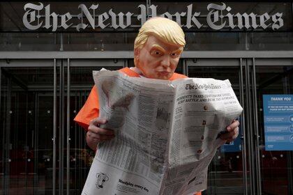 Mike Hisey dressed as U.S. President Donald Trump in a prison jumpsuit reads the New York Times in front of the New York Times office in the Manhattan borough of New York City, New York, U.S., September 28, 2020. REUTERS/Carlo Allegri TPX IMAGES OF THE DAY