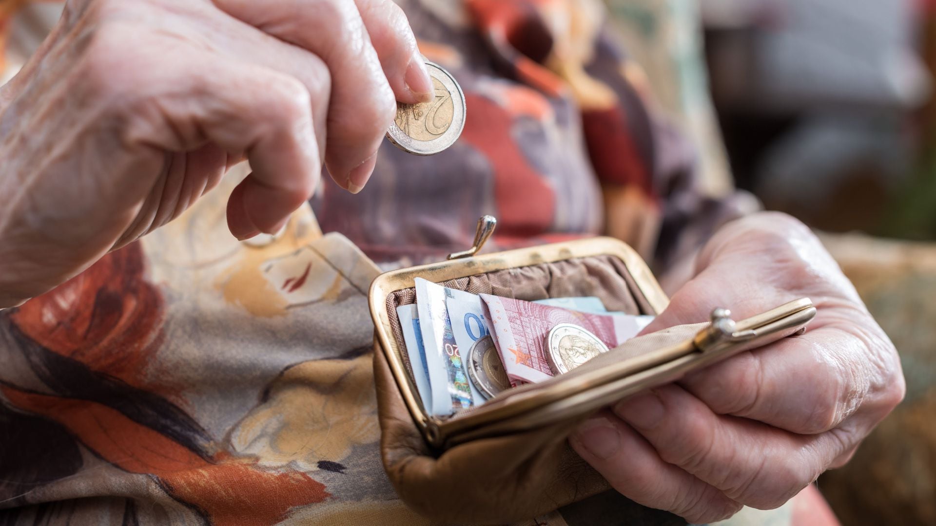 Una jubilada guarda el dinero de su pensión en su monedero (ShutterStock).