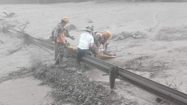 Fotografía cedida por el Ministerio de Defensa de Guatemala, muestra a personal de emergencia rescatando a una persona después de la erupción del volcán de Fuego registrada hoy en Guatemala. (EFE/Ministerio de Defensa Guatemala)
