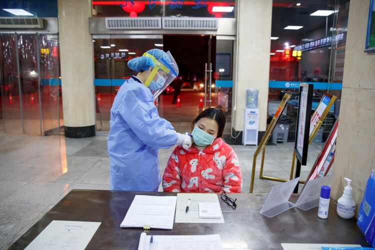 Una enfermera toma la temperatura de una paciente (Reuters)