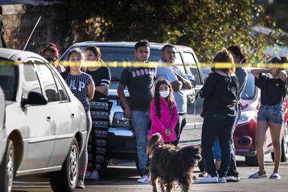Personas en Tijuana observan a una mujer gritando luego de que su esposo fuera asesinado a balazos. Incluso durante la pandemia, se siguen registrando este tipo de incidente violentos con arma en la frontera (Foto: Washington Post/Melina Mara)