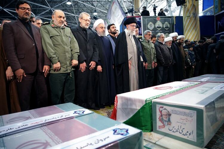 El líder supremo de Irán, el ayatolá Ali Khamenei, y el presidente iraní, Hassan Rouhani, rezan cerca del ataúd del mayor general iraní Qassem Soleimani, jefe de la élite de la Fuerza Quds, quien murió en un ataque aéreo en el aeropuerto de Bagdad, en Teherán, Irán, el 6 de enero de 2020. (Sitio web oficial de la Presidencia iraní via Reuters) 