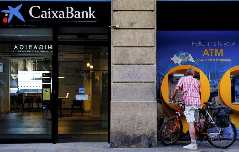 Una persona utiliza un cajero automático de Caixabank en Barcelona. (Nacho Doce / Reuters)