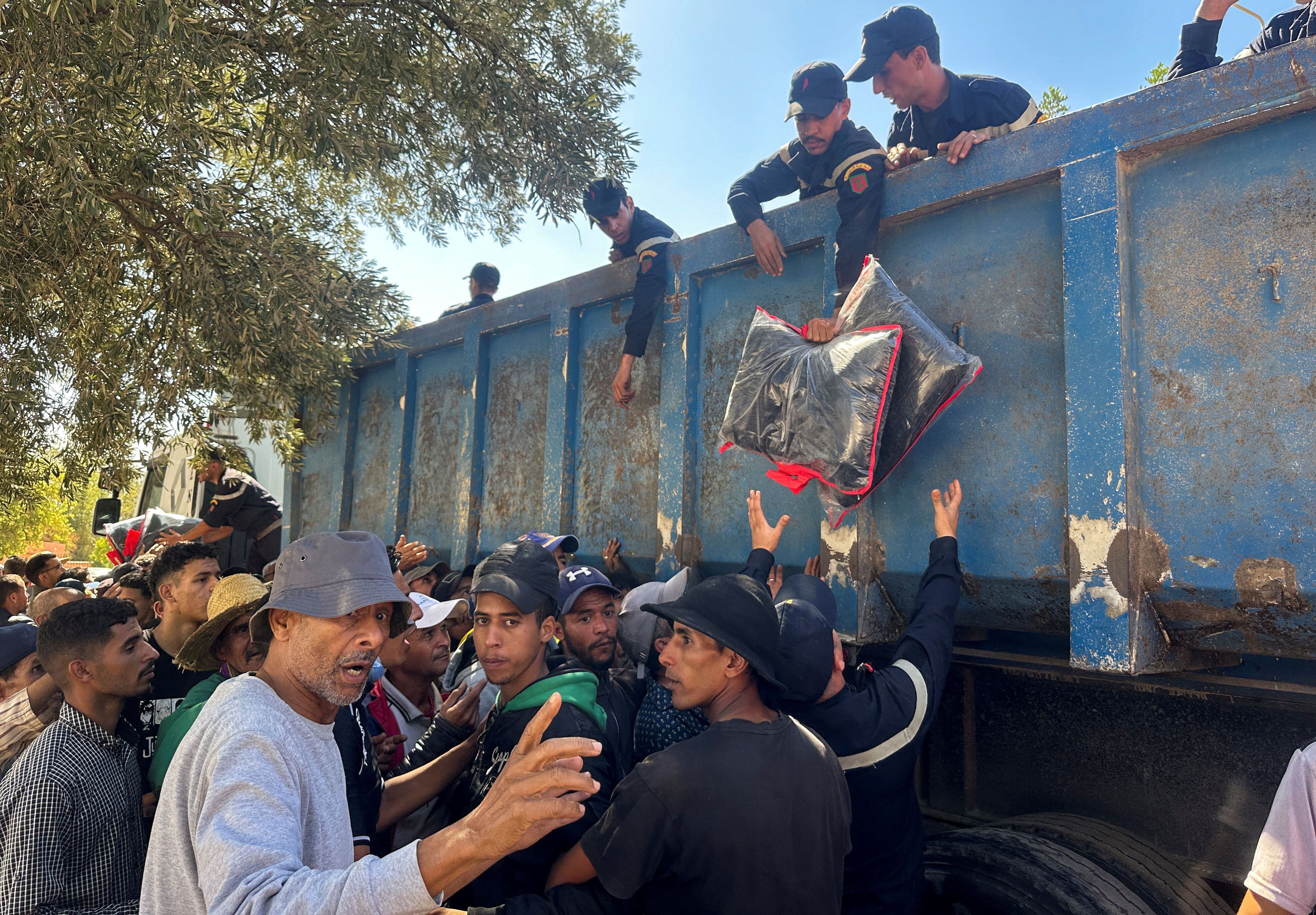 Miembros de los Servicios de Protección Civil de Marruecos distribuyen ayuda a los supervivientes del terremoto en el pueblo de Amizmiz (REUTERS/Miguel Pereira)