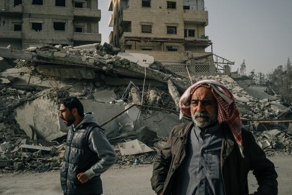 Yehia al-Hayoun, a la derecha, enfrente de un edificio destruído (The Washington Post / Alice Martins)