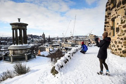 Gente tomando fotos de la nieve en el centro de Edimburgo (Andy Buchanan / AFP)