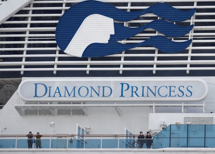 Pasajeros con cubrebocas miran desde la borda del Diamond Princess, atracado en el puerto de Yokojama, al sur de Tokio (Foto: Reuters/Kim Kyung-Hoon)