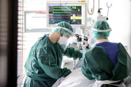 Dos sanitarios atienden a un paciente de covid-19 en el Hospital Universitario de Essen, Alemania. EFE/EPA/FRIEDEMANN VOGEL/Archivo
