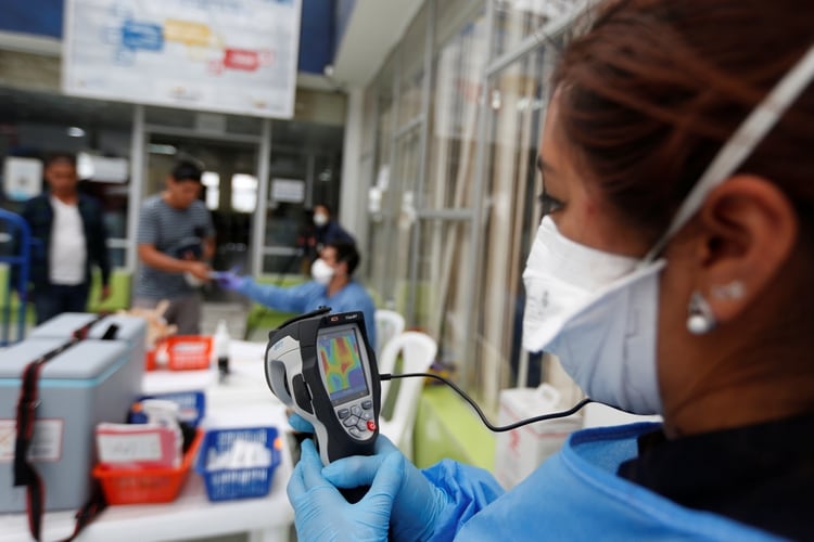 Personal del ministerio de salud verifica la temperatura de un turista en medio del brote de coronavirus, en el puente fronterizo de Rumichaca en Tulcan, Ecuador (REUTERS/Daniel Tapia)