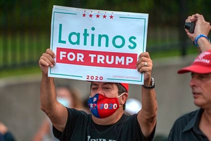 Una hombre sostiene una pancarta con el lema "Latinos por Trump" durante un acto en Miami, Florida (EFE/Giorgio Viera)