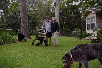 Mike Teal, quien está tomando un fármaco experimental para retardar la progresión de la esclerosis lateral amiotrófica (ELA), con su esposa Lauren y sus perros Lucy y Jack en su casa en Tallahassee, Florida (Aileen Perilla / The New York Times)