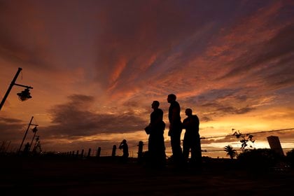 Bomberos en Port Arthur miran al mar durante el atardecer a la espera de la llegada del huracán Laura, el 26 de agosto de 2020, en Port Arthur, Texas. (AP Foto/Eric Gay)