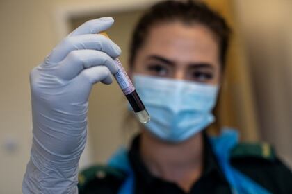Una trabajadora sanitaria con una muestra de sangre. Foto: Simon Dawson/ via REUTERS