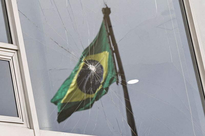 La bandera de Brasil se refleja en una ventana rota. REUTERS/Ueslei Marcelino/Archivo