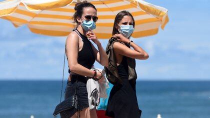 Mujeres con mascarilla en una playa francesa el 3 de agosto del 2020 (Photo by GAIZKA IROZ / AFP)