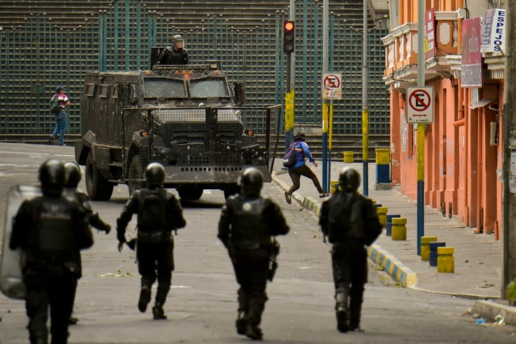 Riot police chase a protestor during a transport strike against the economic policies of the government of Ecuadorean President Lenin Moreno regarding the agreement signed on March with the International Monetary Fund (IMF), in Quito, on October 4, 2019. - The Ecuadorean government confirmed possible labour and tax reforms as established in the agreement, Economy Minister Richard Martinez stated -a day after announcing the elimination of fuel subsidies. (Photo by RODRIGO BUENDIA / AFP)