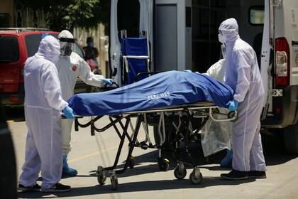 Paramédicos transportan el cuerpo de un hombre que murió de la enfermedad por coronavirus (COVID-19) antes de ser trasladado a un hospital en Ciudad Juárez, México, el 26 de mayo 2020. REUTERS/Jose Luis Gonzalez