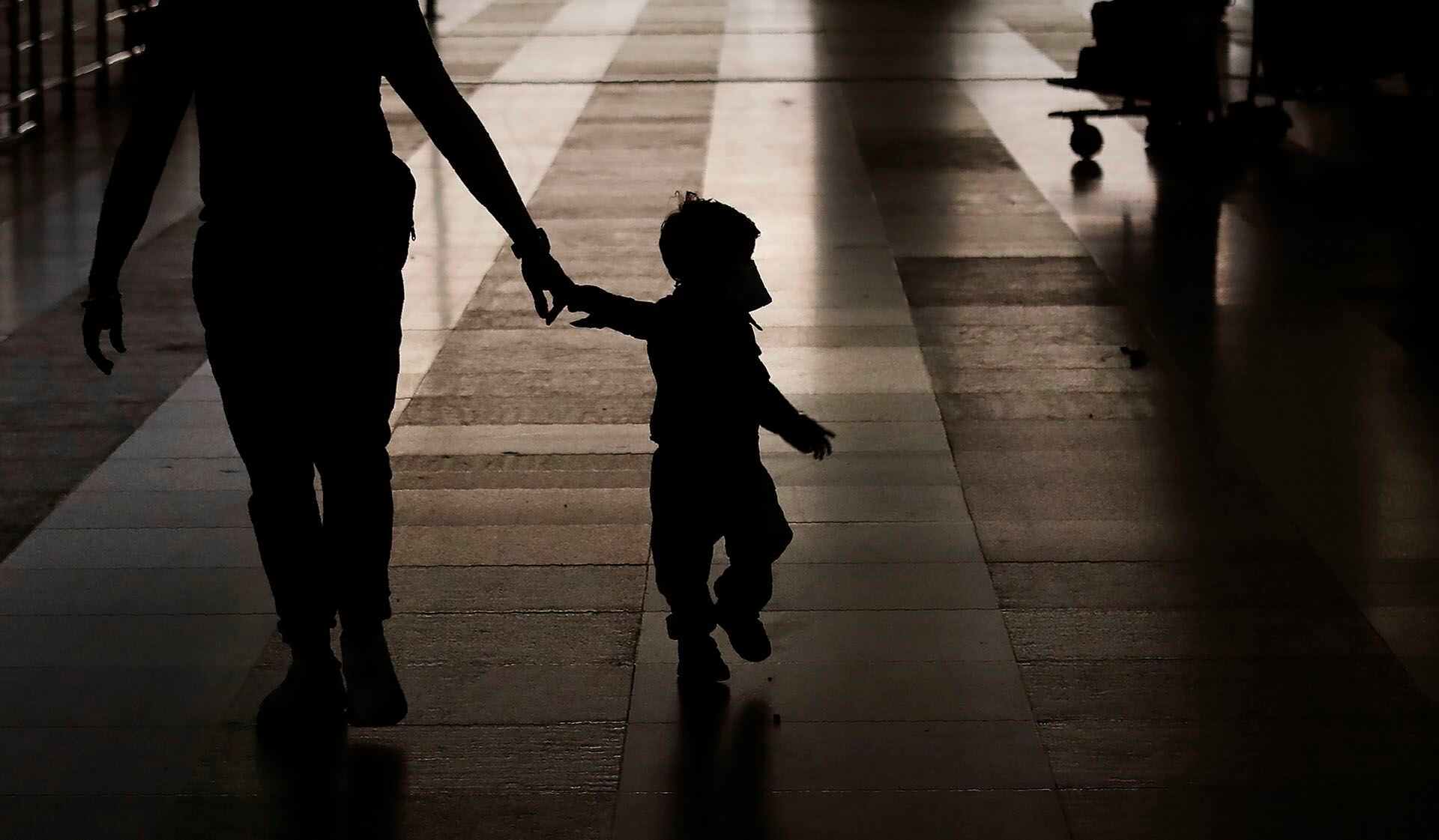 Un ciudadano neozelandés varado con su hijo con una máscara facial llega a bordo de un vuelo de repatriación de vuelta a casa en el aeropuerto internacional Indira Gandhi de Nueva Delhi, India, el jueves 23 de abril de 2020 (Foto AP/Manish Swarup)