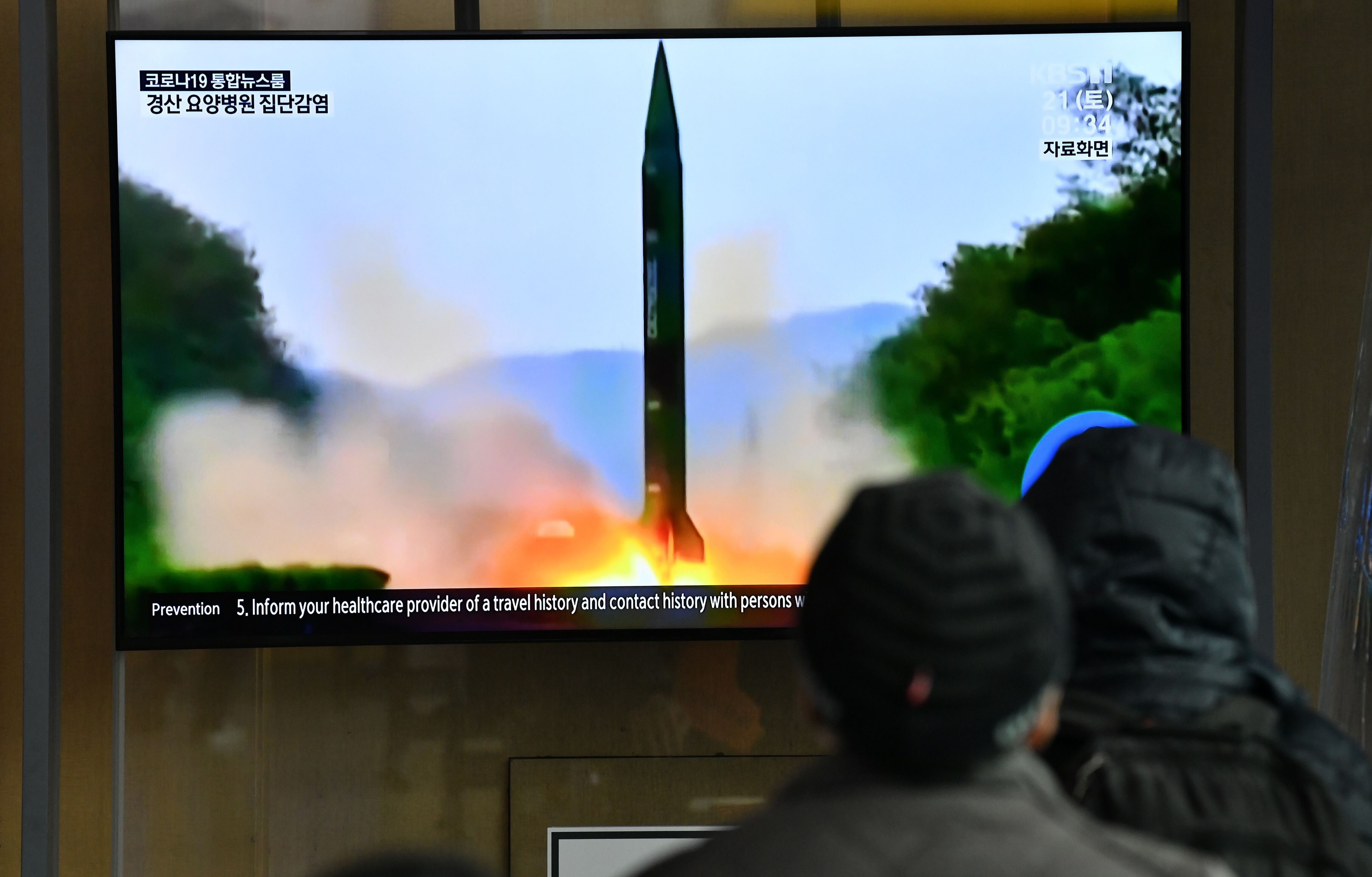 Un grupo de personas en Corea del Sur mira un lanzamiento de cohetes en Corea del Norte. (Photo by Jung Yeon-je / AFP)