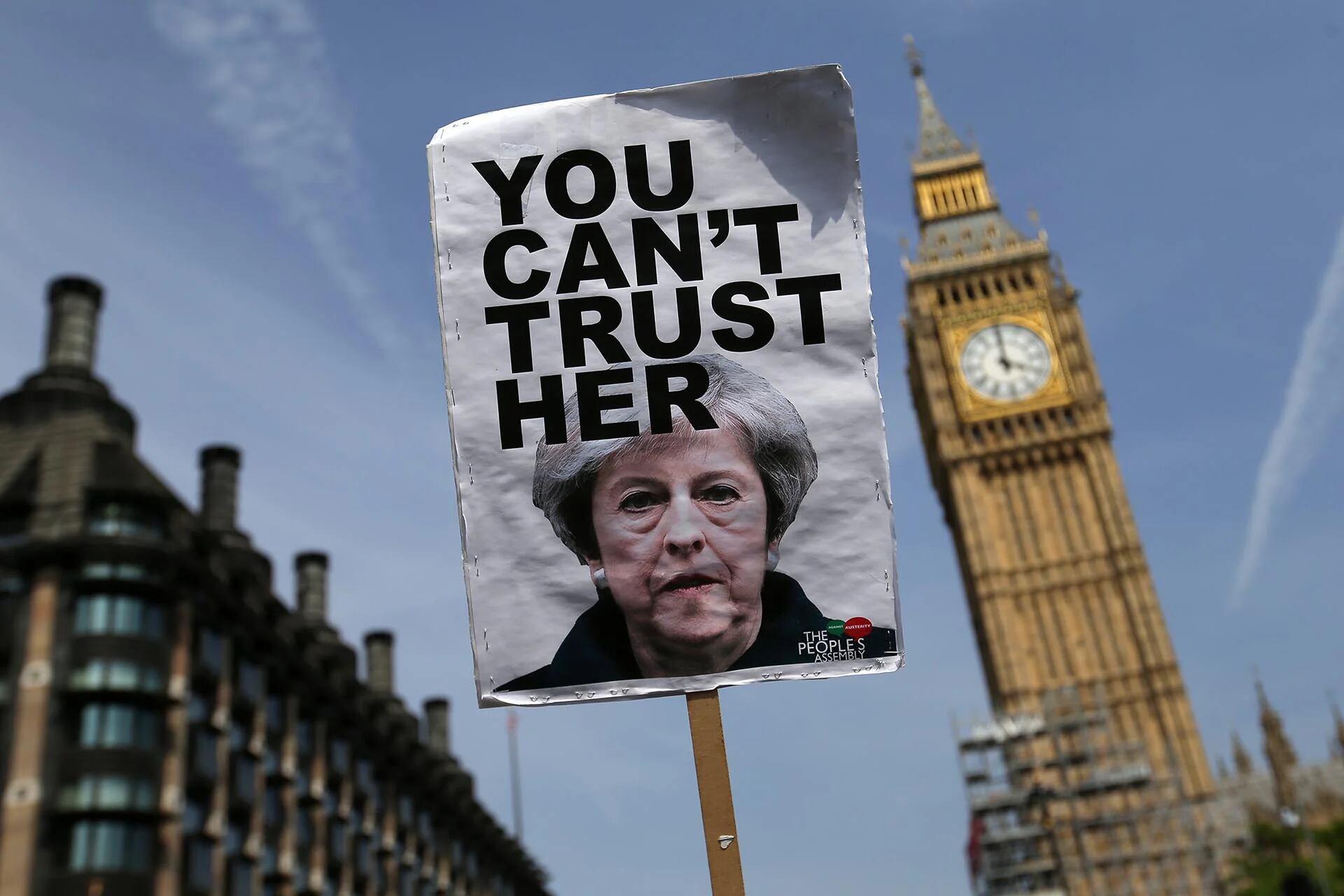 Un cartel, que muestra una foto de la premier británica Theresa May y dice “No se puede confiar en ella”, frente al Big Ben en una protesta durante la sesión de apertura del Parlamento