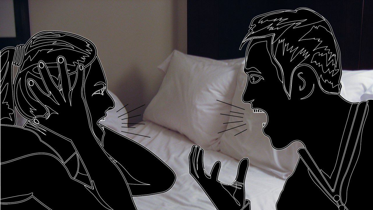 Dos personas discuten frente a una cama.