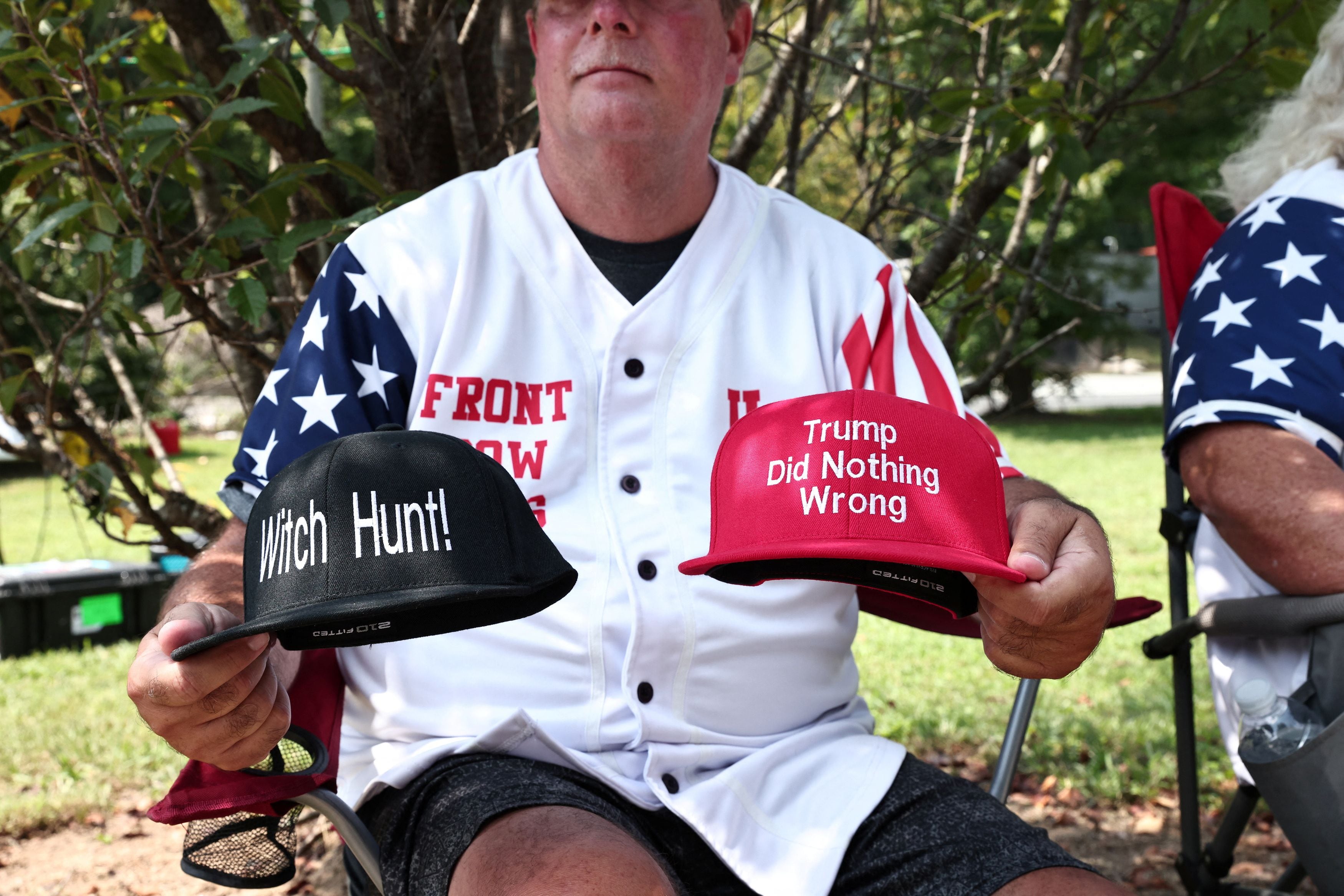 Un partidario de Trump muestra sus gorras que dicen "Caza de brujas" y "Trump no hizo nada malo" (REUTERS/Dustin Chambers)
