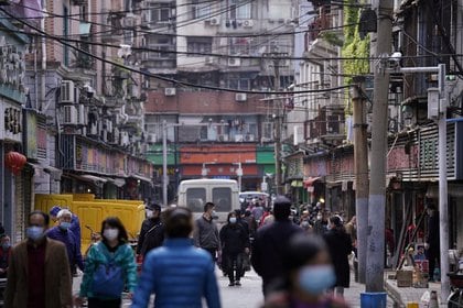 Personas utilizando mascarillas caminan en una calle comercial en Wuhan (Reuters)