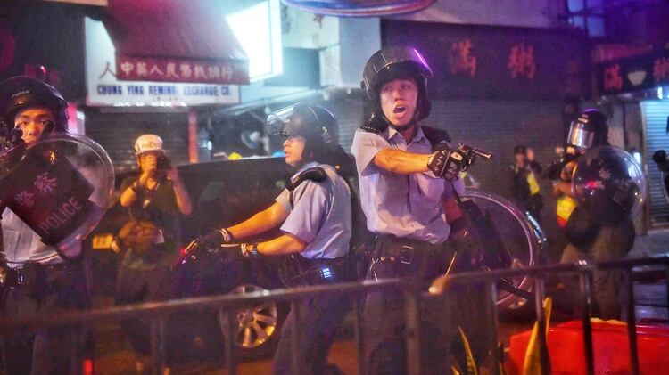 La policía apuntando con armas de fuego a los manifestantes en Hong Kong (Photo by Lillian SUWANRUMPHA / AFP)