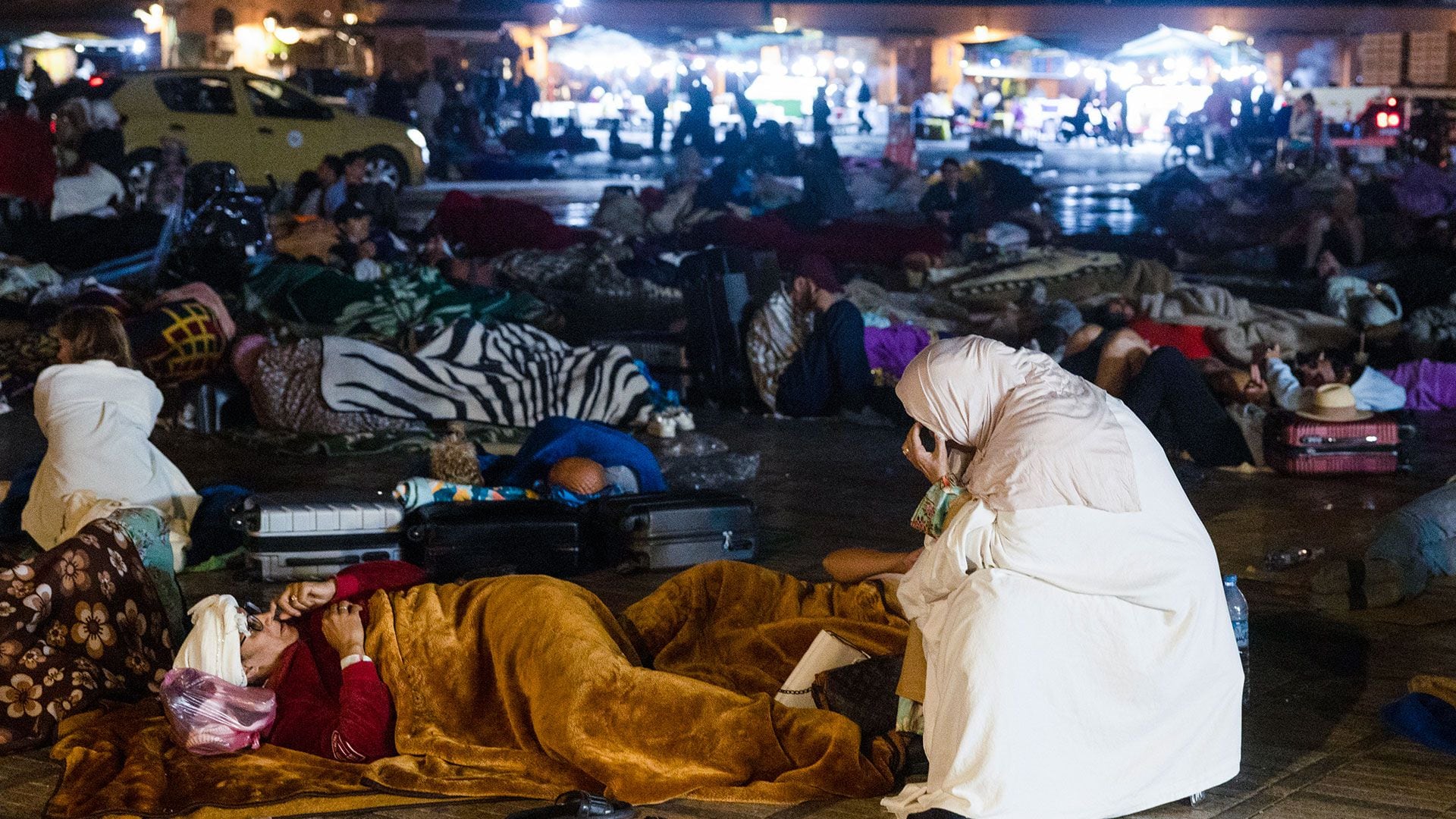 Residentes permanecen a la intemperie en una plaza de Marrakech el 9 de septiembre de 2023 (Fadel Senna/AFP)