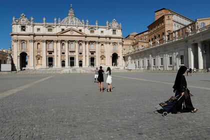 ARCHIVO FOTOGRÁFICO: Una monja pasa cerca de turistas tomando fotos en la Plaza de San Pedro mientras el Papa Francisco da su audiencia general semanal virtualmente desde una biblioteca dentro del Vaticano en el Vaticano el 5 de agosto de 2020. REUTERS/Remo Casilli