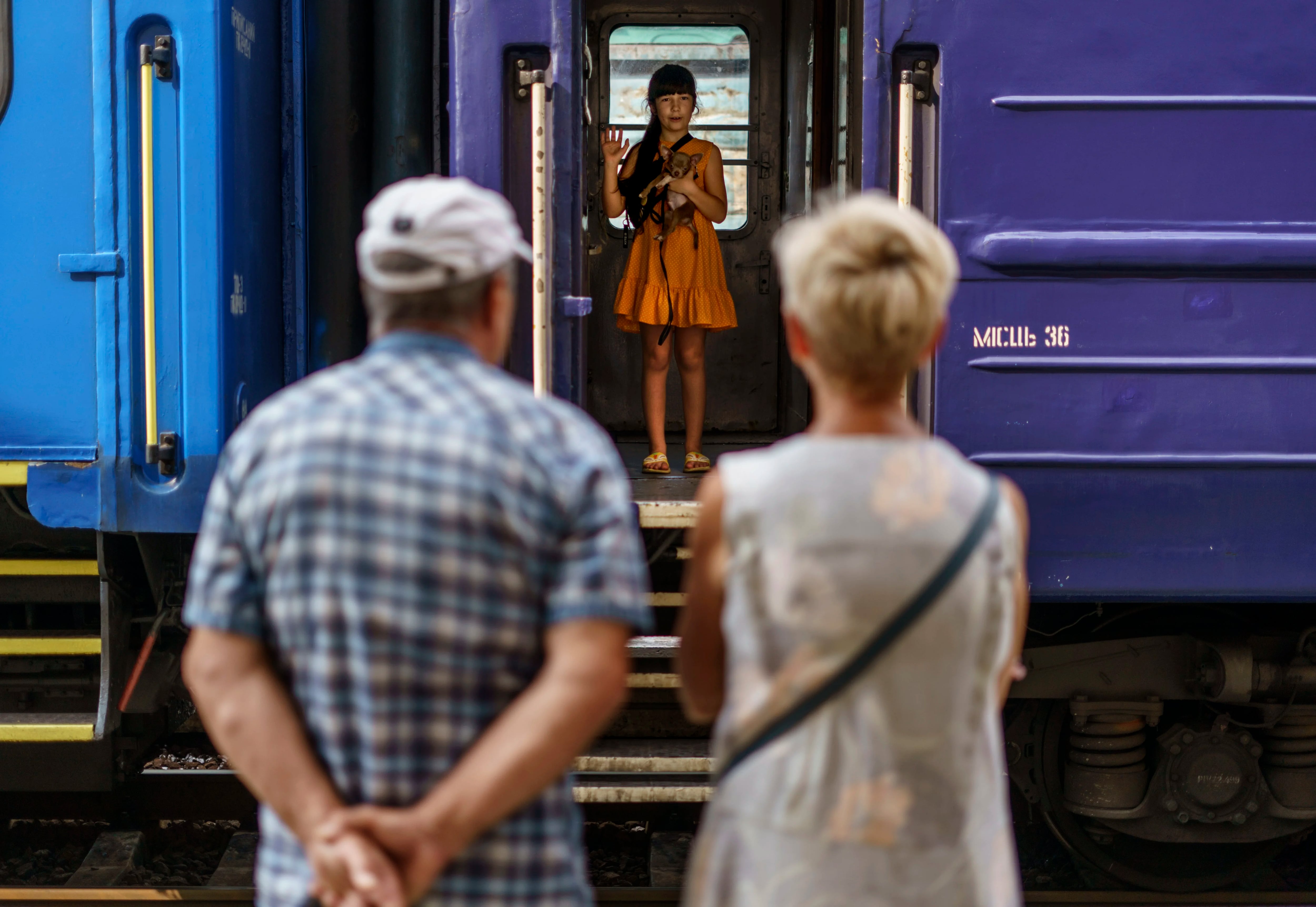 Una niña sostiene a su perro mientras se despide de sus abuelos desde un tren de evacuación que partió de Pokrovsk, región de Donetsk, este de Ucrania, el martes 2 de agosto de 2022, hacia una parte más segura del país hacia el oeste.