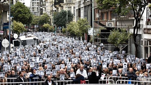 La gente muestra carteles con los rostros de las víctimas del ataque a la AMIA (Foto: A. Escandar)