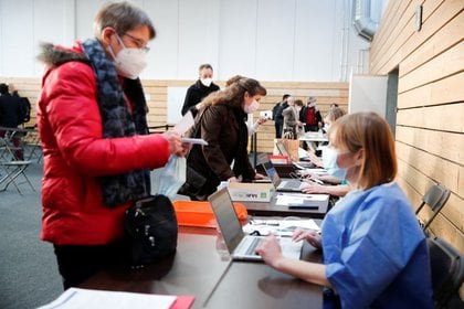Trabajadores de la salud registrándose para recibir la vacuna COVID-19 de Pfizer-BioNTech en un centro de vacunación dentro de un gimnasio en Taverny cerca de París, Francia, el 9 de enero de 2021 (REUTERS/Benoit Tessier)