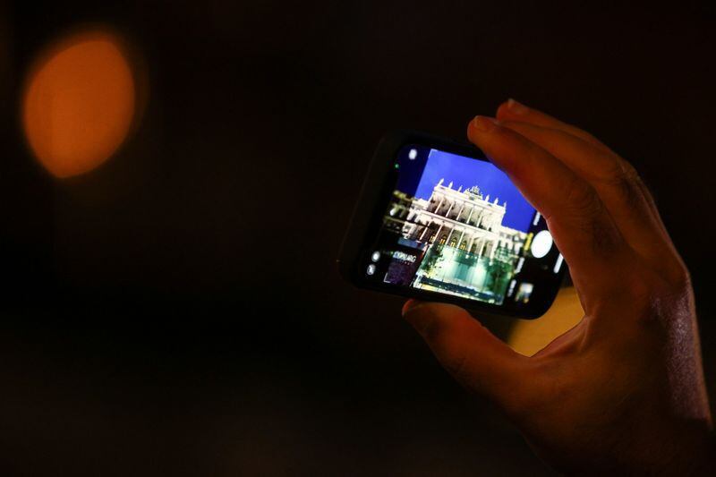 Imagen de archivo de un periodista fotografiando con su móvil el Palais Coburg, donde se celebran las negociaciones nucleares con Irán, en Viena, Austria. 29 noviembre 2021. REUTERS/Lisi Niesner