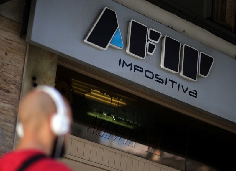 Un hombre camina frente a la entrada de una oficina de la AFIP (Reuters)