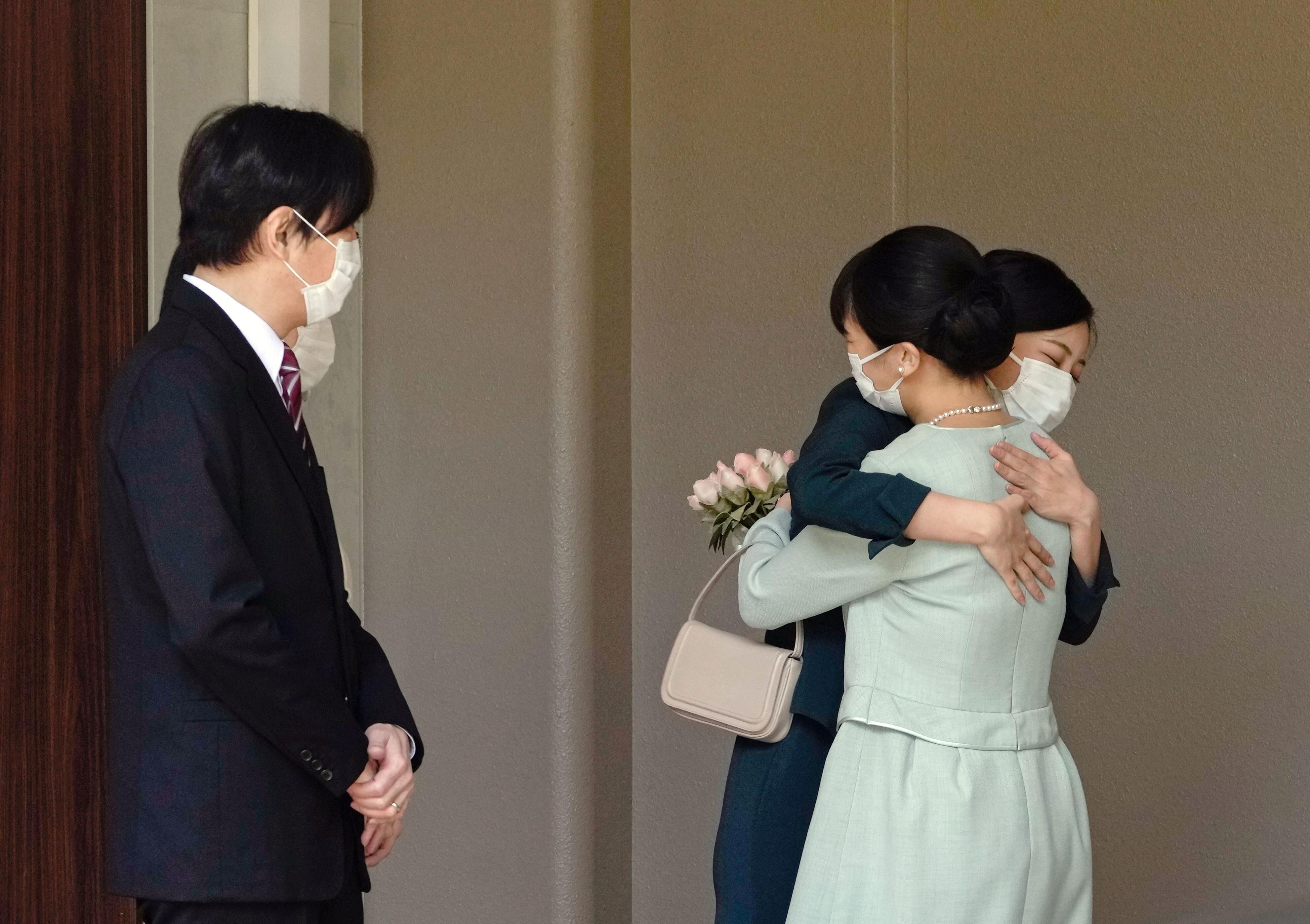 La princesa Mako de Japón abraza a su hermana, la princesa Kako, y son observadas por sus padres, el príncipe heredero Akishino y la princesa heredera Kiko, antes de salir de su casa para casarse en Akasaka Estate en Tokio, Japón, el 26 de octubre de 2021 en esta foto tomada por Kyodo. Kyodo / via REUTERS 